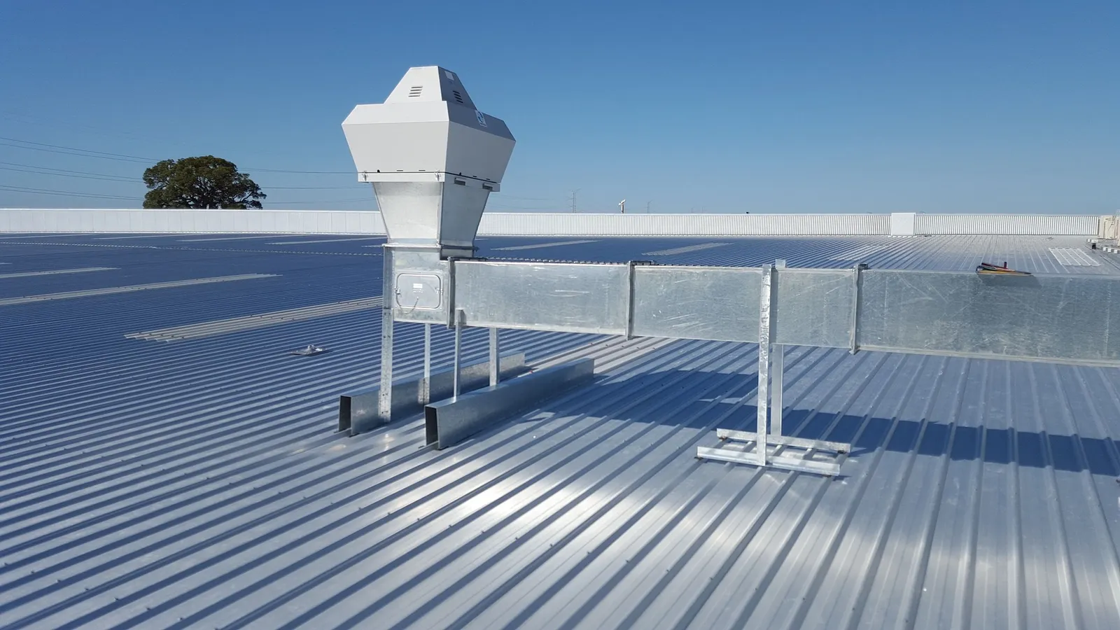 Corrugated metal commercial roof with rooftop vent and ductwork